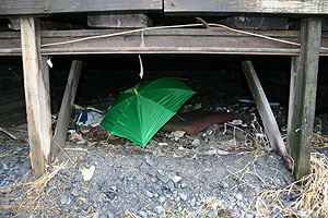 BEKSYTTELSE: En grønn paraply er satt opp for å skjerme mot vind og nedbør.